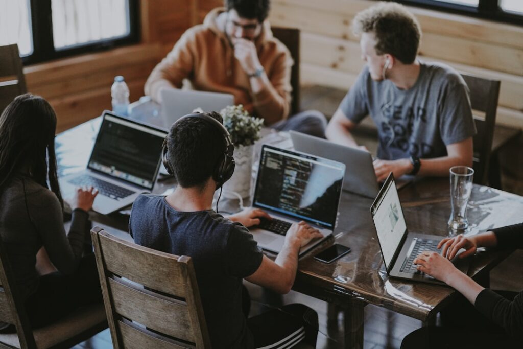 Personas sentadas en una mesa estudiando gráficos con herramientas de análisis de datos.

